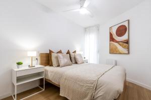 a white bedroom with a bed and a window at Exclusive Apartments Barcelona 4 personas Torrella in Terrassa