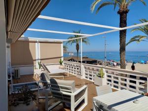 a balcony with white chairs and a view of the beach at Apartment Paseo in Aguadulce