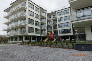 an apartment building with a playground in front of it at APARTAMENT PRZY PLAŻY 2 in Rowy