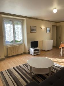 sala de estar con mesa y TV en Appart Hotel Avril de la Roche, en Angers