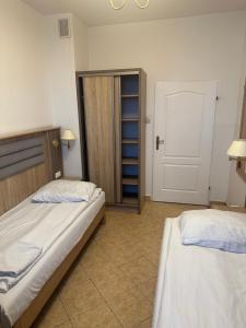 1 Schlafzimmer mit 2 Betten und einer Tür zu einem Schrank in der Unterkunft Lotos in Rawicz
