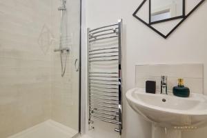 a white bathroom with a sink and a shower at Stunning 5Bed All En-suite Headingley Home in Headingley