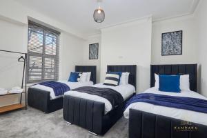 a bedroom with two beds with blue and white sheets at Stunning 5Bed All En-suite Headingley Home in Headingley