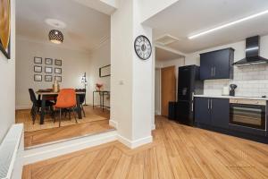 a kitchen and dining room with a clock on a wall at Stunning 5Bed All En-suite Headingley Home in Headingley