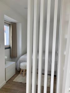 a bedroom with a bed with striped walls at Alojamento confortável a 2 min da Praia in Horta
