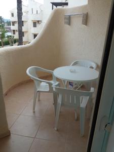 - Balcón con mesa blanca y sillas en Apartamento Urb La Felicidad, en Denia