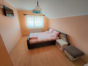 a small bedroom with a bed and a window at Apartments Nikolić in Soko Banja