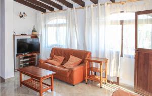 a living room with a leather couch and a tv at Awesome Home In Tosal With Jacuzzi in La Nucía
