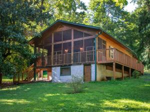 a large house with a large deck in the grass at A Garden Blessing, 1 Bedroom, Hot Tub, Fireplace, Grill, WiFi, Sleeps 4 in Gatlinburg