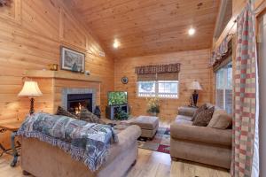 a living room with couches and a fireplace in a log cabin at A Garden Blessing, 1 Bedroom, Hot Tub, Fireplace, Grill, WiFi, Sleeps 4 in Gatlinburg