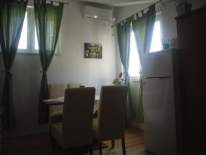 a kitchen with a table and chairs and a refrigerator at Apartmani Emi in Tučepi