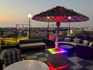 a rooftop patio with an umbrella and couches and lights at Casa De SAF, Near Sea View, Mc Donalds, Hyper Market in Karachi