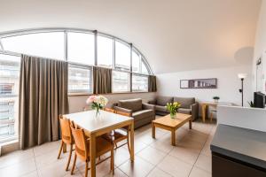 - un salon avec un canapé et une table dans l'établissement Belcasa Suitehotel, à Middelkerke