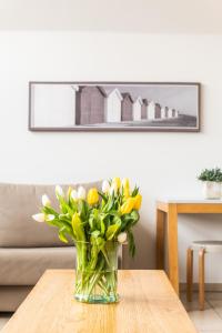 een vaas met bloemen op een tafel in een woonkamer bij Belcasa Suitehotel in Middelkerke