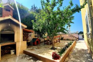 a patio with a tree and a bench and a house at SUN apartment with SEA VIEW and shared POOL in Split