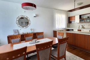 a dining room with a table and chairs and a kitchen at SUN apartment with SEA VIEW and shared POOL in Split