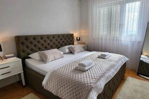 a bedroom with a large bed with two towels on it at SUN apartment with SEA VIEW and shared POOL in Split +21 photos