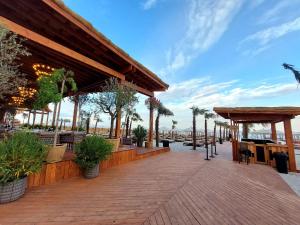 a boardwalk with tables and chairs and palm trees at Seaside Blues Apartment Located in 5 Star Resort in Năvodari
