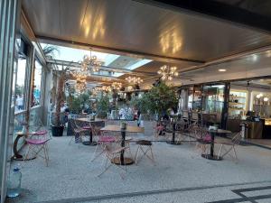 a restaurant with tables and chairs in a building at Seaside Blues Apartment Located in 5 Star Resort in Năvodari