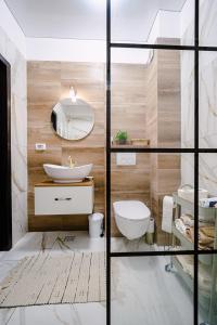 a bathroom with a white toilet and a sink at Seaside Blues Apartment Located in 5 Star Resort in Năvodari +10 photos