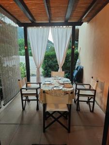 uma sala de jantar com uma mesa e cadeiras e uma janela em Elbamare residence con piscina em Nisporto