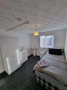 a bedroom with a bed and a sink and a ceiling at 70 Southfield in Middlesbrough