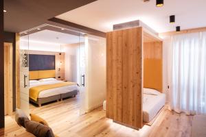 1 dormitorio con 2 camas y un espejo grande en Hotel Piccola Baita, en Molveno