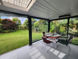 a dining room with a table and chairs on a patio at La Petite Ferme Manor Kerikeri in Kerikeri