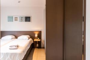 a bedroom with two beds and a table with a lamp at Belcasa Suitehotel in Middelkerke