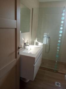 een badkamer met een witte wastafel en een douche bij Olive Trees in Tragaki