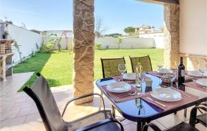 una mesa y sillas en un patio con vistas a un patio en Stunning Home In Chiclana De La Fronter With 2 Bedrooms, en Chiclana de la Frontera