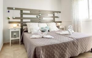2 Bedroom Awesome Home In Chiclana De La Fronter في شيكلانا دي لا فرونتيرا: غرفة نوم عليها سرير وبجعتين