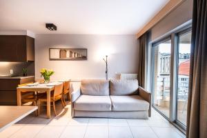 a living room with a couch and a table at Belcasa Suitehotel in Middelkerke