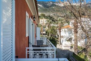 una casa con balcón con mesa y sillas en Angela sea view 7, en Cefalonia 5 fotos más