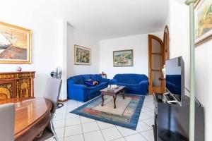 sala de estar con sofá azul y TV en Viareggio Beach Apartment, en Viareggio