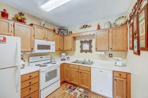 eine Küche mit weißen Geräten und Holzschränken in der Unterkunft Dream a Little Dream Whispering Pines 411 in Pigeon Forge