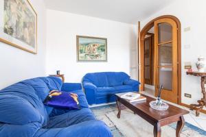 sala de estar con sofá azul y mesa en Viareggio Beach Apartment, en Viareggio