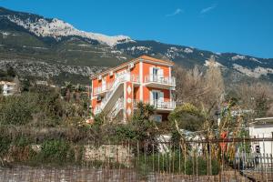 an orange house on a hill with mountains in the background at Angela partial sea view 8 in Kefallonia