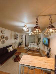 a living room with two hanging lights and a table at Boho Chic Themed Condo near SM Marilao in Marilao