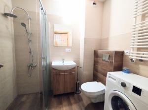 a bathroom with a toilet and a sink and a shower at Yellow Apartment in Wieliczka