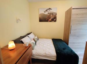 um quarto com uma cama e uma mesa de madeira em Yellow Apartment em Wieliczka