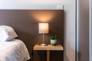 eine Lampe auf einem Tisch neben einem Bett in der Unterkunft Belcasa Suitehotel in Middelkerke