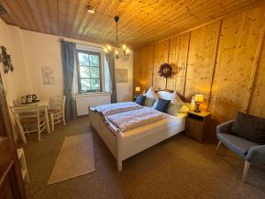 a bedroom with a bed and a table and a chair at Landhaus Tannenhof in Lind