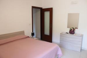 une chambre avec un lit, une commode et un miroir dans l'établissement LA CASETTA DI ASIA, à Vico Equense
