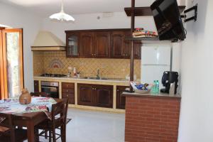 une cuisine avec des placards en bois et une table avec une salle à manger dans l'établissement LA CASETTA DI ASIA, à Vico Equense 37 autres photos