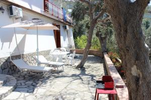 - une terrasse avec des chaises et un parasol à côté d'un bâtiment dans l'établissement LA CASETTA DI ASIA, à Vico Equense