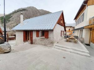 a small house with a mountain in the background at Maison Aux portes d'Emparis in Mizoën