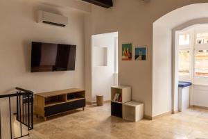 a living room with a flat screen tv on the wall at Valletta Collection - St. Domenic Duplex in Valletta