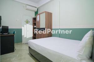 Ένα ή περισσότερα κρεβάτια σε δωμάτιο στο Pondok Hijau Syariah Mitra RedDoorz At Citraland Surabaya