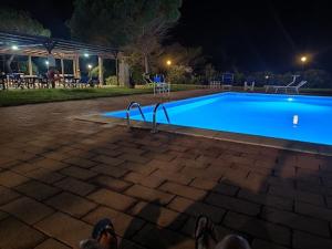a person laying in front of a swimming pool at night at Elbamare residence con piscina in Nisporto +21 photos